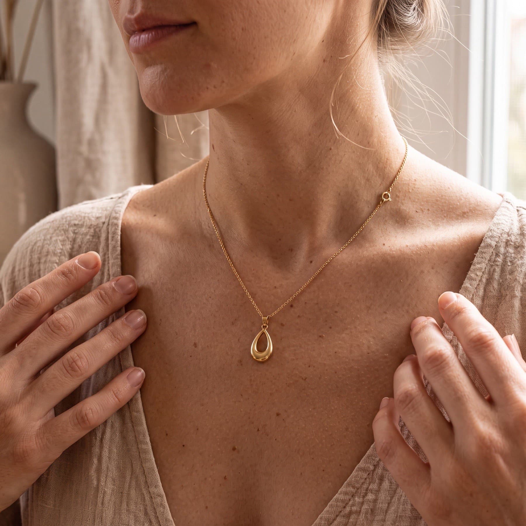 A necklace lying on a bathroom counter, and the same necklace worn by a model